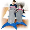 A father and son are sitting on a white rug in front of a fireplace, both wearing shark-themed blankets. Anteprima dell’immagine prodotto