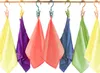 Several colorful cloths are hanging on a wooden rod with clips and hooks. Anteprima dell’immagine prodotto