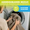 A person is holding a folded blanket in front of an open washing machine. Produktbild-Vorschau