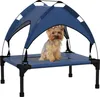 A small dog sitting on a raised pet bed with a canopy. Anteprima dell’immagine prodotto