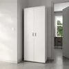 A white two-door cabinet is shown in a hallway, with a doorway leading to another room with a desk and window. Voir les images du produit