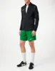 A man wearing a black Nike jacket and green Nike shorts, standing against a white background. Produktbild-Vorschau
