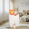 A laundry basket filled with stuffed animals in a bedroom setting. Produktbild-Vorschau