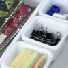 A close-up view of several white modular drawer organizers filled with office supplies. Náhľad obrázku produktu