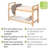 A bamboo shoe bench with a cushion and two shelves, shown with a blanket and shoes. Náhled obrázku produktu