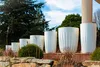 Several white planters of varying sizes are arranged on a ledge in an outdoor setting, with trees and a blue sky in the background. Anteprima dell’immagine prodotto