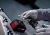 A person wearing gloves is inserting a drill bit into a cordless drill. Podgląd zdjęcia produktu