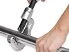 A close-up shot of a person using a pipe cutter on a metal pipe. Anteprima dell’immagine prodotto