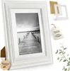 A white wooden picture frame with a black and white photograph of a pier on a lake. Anteprima dell’immagine prodotto