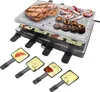 A raclette grill with food on it, and several raclette pans in the foreground. Produktbild-Vorschau