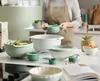 A kitchen scene with various mixing bowls and measuring cups. Produktbild-Vorschau