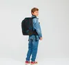 A young boy wearing a denim jacket and jeans, with a patterned backpack, stands against a white background. Produktbild-Vorschau