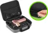 A pink and gold massage gun with multiple attachments is displayed inside its gray carrying case. The case is open, revealing the organized interior. A close-up inset shows a hand zipping up a similar case. Produktbild-Vorschau