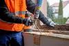 A person is using a construction adhesive foam dispenser to seal a window frame. Produktbild-Vorschau