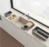 A modern kitchen sink area with various accessories laid out on the countertop. Voir les images du produit