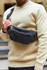 A man wearing a light yellow sweater and a black fanny pack. Voir les images du produit