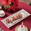 A festive table setting with a cake on a decorative platter, flowers, and candles. Náhľad obrázku produktu