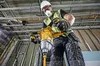 A construction worker is using a DeWALT mixer in a building under construction. Podgląd zdjęcia produktu