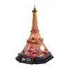 A 3D puzzle model of the Eiffel Tower, presented as a night version with red lighting on its base. Voir les images du produit