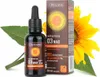 A bottle of vitamin D3 drops next to its packaging, with a sunflower and leaves in the background. Produktbild-Vorschau