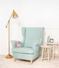 A plush bunny sits on a light blue armchair next to two small side tables. A floor lamp stands to the left, and a vase and alarm clock are on one of the tables. Náhľad obrázku produktu