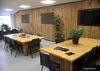 A meeting room with bamboo-paneled walls, tables, and chairs. Produktbild-Vorschau