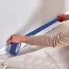 A person is applying blue painter's tape along the baseboard of a wall. Anteprima dell’immagine prodotto