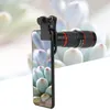 A smartphone with a telephoto lens attachment clipped to it, with a blurred background of succulents. Náhled obrázku produktu