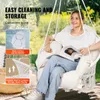 A woman is sitting in a white macrame hanging chair outdoors, reading a magazine. Podgląd zdjęcia produktu