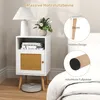 A white nightstand with a rattan door is shown next to a bed. Inset images highlight the wooden legs and felt pads. Náhled obrázku produktu