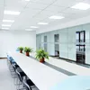 A modern conference room with a long table and chairs, illuminated by ceiling lights. Produktbild-Vorschau
