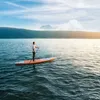 A person is paddleboarding on a lake with mountains in the background. Náhľad obrázku produktu