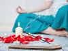 A person meditating with incense, candles, and rose petals. Produktbild-Vorschau