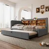 A grey upholstered daybed with a pull-out trundle bed is shown in a bedroom setting. Anteprima dell’immagine prodotto