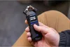 A person is holding a black Zoom H1 Essential Handy Recorder. Produktbild-Vorschau