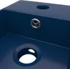 A close-up view of a dark blue ceramic bathroom sink, showing the drain and a second circular opening. Náhled obrázku produktu