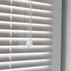 Close-up of white horizontal blinds with pull cords. Produktbild-Vorschau