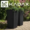 Two tall black planters with plants in them, set on a paved patio with greenery in the background. Náhľad obrázku produktu