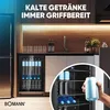 A modern kitchen scene featuring a beverage cooler filled with cans and bottles, with a hand holding a can in the foreground. Anteprima dell’immagine prodotto