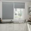 A kitchen sink area with a window covered by roller blinds. Voir les images du produit