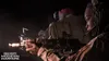 Two soldiers in tactical gear, one aiming a rifle, in a dark environment. Produktbild-Vorschau