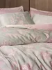 A close-up view of a bed with a duvet cover and pillows. Produktbild-Vorschau