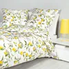 A bed with a duvet and pillows featuring a lemon pattern. Produktbild-Vorschau