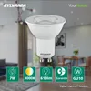 A Sylvania GU10 LED bulb is shown in the foreground, with a blurred interior room scene in the background. Produktbild-Vorschau