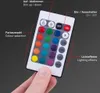 A hand holding an LED remote control with various color and function buttons. Anteprima dell’immagine prodotto