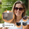 A woman is smiling while sitting in a chair, with a product image of a polyrattan side table and smaller images of the same table in different colors. Produktbild-Vorschau