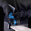 A person wearing black gloves is holding a blue cordless multi-tool and preparing to cut a piece of wood. Náhled obrázku produktu