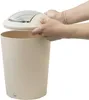 Hands are shown placing the lid on a beige trash can. Produktbild-Vorschau
