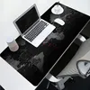 A desk setup with a laptop, mousepad featuring a world map, a cup, and a mouse. Náhled obrázku produktu
