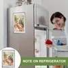 A woman is smiling and holding a red bell pepper while standing in front of an open refrigerator. A framed picture is attached to the refrigerator door. Náhľad obrázku produktu